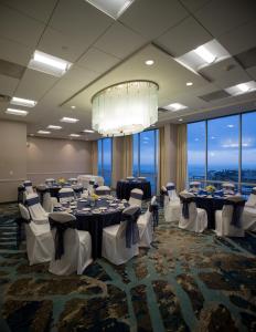 una sala de conferencias con mesas, sillas y una lámpara de araña en Crowne Plaza Hotel Ventura Beach, an IHG Hotel, en Ventura