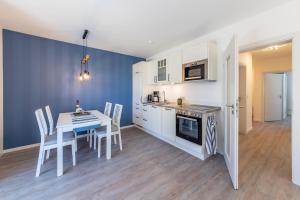 a kitchen and dining room with a table and chairs at Dünenkieker Ferienwohnung in Lubmin