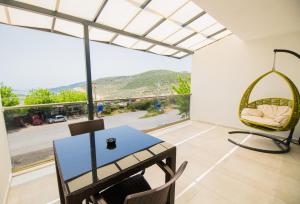 a room with a table and chairs and a large window at MULBERRY SUİT APART in Kaş