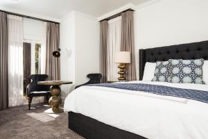 um quarto com uma cama grande, uma mesa e cadeiras em Hotel Ella em Austin