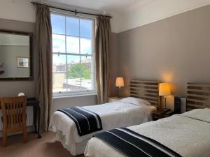 a hotel room with two beds and a window at Harveys Guest House in Dublin