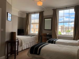 a hotel room with two beds and a window at Harveys Guest House in Dublin
