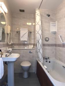 uma casa de banho com um lavatório, uma banheira e um WC. em Harveys Guest House em Dublin
