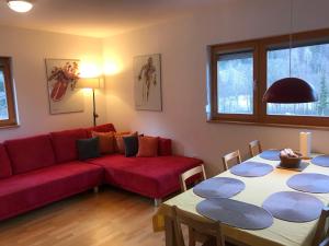 a living room with a red couch and a table at Apartment Lesnina in Kranjska Gora