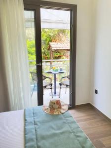 a bedroom with a bed and a table and a balcony at Villa Sofia Fresh in Limenaria