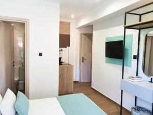 a bedroom with a bed and a tv on a wall at Villa Sofia Fresh in Limenaria