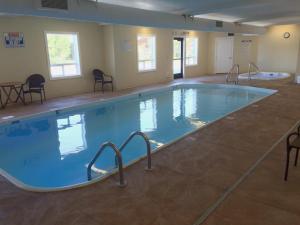 a large swimming pool in a room with chairs at Yellowstone Lodge in West Yellowstone