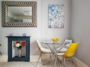 ein Esszimmer mit einem Tisch, Stühlen und einem Spiegel in der Unterkunft Elegantly Restored Suite in Historic Limerick in Limerick