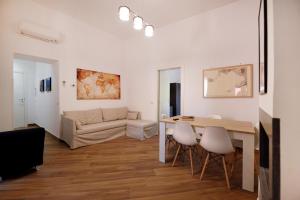 - un salon avec une table, des chaises et un canapé dans l'établissement The Wanderlast Sorrento, à Sorrente
