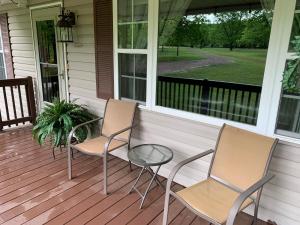 twee stoelen en een tafel op de veranda van een huis bij GabyHill in Davis