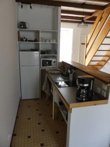 La cuisine est équipée d'un comptoir et d'un réfrigérateur. dans l'établissement Petit gite du Puy Lambert, à La Flocellière