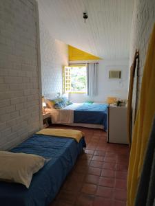 1 dormitorio con 2 camas y cocina con ventana en Casa Porto de Galinhas, en Porto de Galinhas