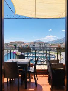 a balcony with a table and chairs and a view of a harbor at Kasa Kala Rooms & Apartments in Palermo