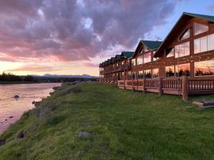 eine Lodge am Ufer eines Flusses mit Sonnenuntergang in der Unterkunft Angler's Lodge in Island Park