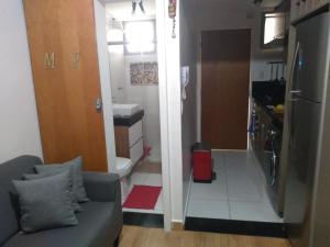 pequeña sala de estar con sofá y cocina en The Flat 15 en Campinas