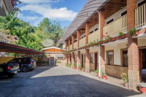 een rij gebouwen met auto's geparkeerd op een parkeerplaats bij Pousada Beira Rio in Santo Antônio do Pinhal
