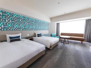 a hotel room with two beds and a couch at Okinawa Grand Mer Resort in Okinawa City