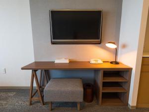 a desk with a television on a wall with a chair at Okinawa Grand Mer Resort in Okinawa City
