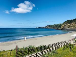 a beach with a fence and the ocean at Casa da Cascata do Segredo in Praia