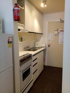 a kitchen with a stove and a sink and a refrigerator at Shamrock Apartment 5 in Mount Hotham +2 photos