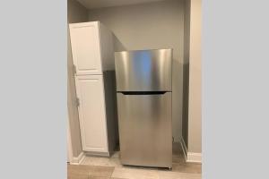 um frigorífico de aço inoxidável no canto de um quarto em Luxury Private Home in the Heart of Niagara Falls em Niagara Falls