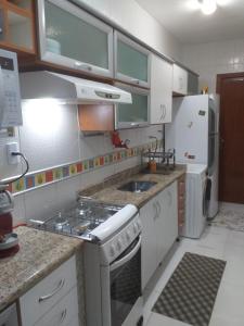 una pequeña cocina con fogones y nevera. en Mega Apartamento, en Río de Janeiro