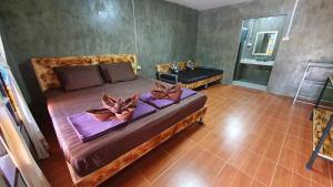 - une chambre avec un grand lit fleuri dans l'établissement Moonshine Resort Chumphon, à Chumpon