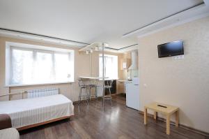 オムスクにあるOmsk Sutki Apartment on Zhukovaのベッドルーム1室(ベッド1台付)、キッチン(テーブル付)