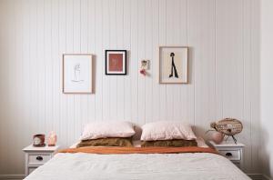 a bedroom with a bed with three pictures on the wall at Anchor Geelong in Geelong