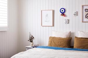 a bedroom with a bed and some pictures on the wall at Anchor Geelong in Geelong