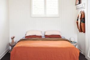 a bedroom with a bed with an orange blanket at Anchor Geelong in Geelong