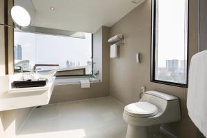a bathroom with a toilet, sink, and bathtub at Cape Dara Resort - SHA Plus in Pattaya North