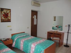 a bedroom with two beds and a desk and a mirror at Locanda del Vecchio Maglio in Terni