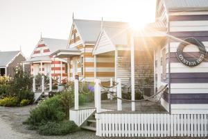a row of houses with a white fence at Beach Huts Middleton in Middleton