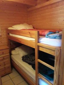 a bedroom with two bunk beds in a cabin at chalet cathy in Laveissière
