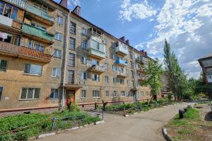 a large brick building with a pathway in front of it at Omsk Sutki Apartments on Mira 10 in Omsk