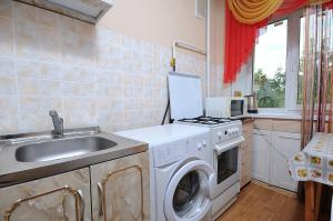 a kitchen with a washing machine and a sink at Omsk Sutki Apartments on Mira 10 in Omsk