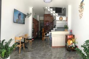 a hallway with a staircase and a table and chairs at Jasmine Mini Hotel in Hue