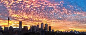 a city skyline with a cloudy sky at sunset at Zen Harmony House Sydney in Sydney