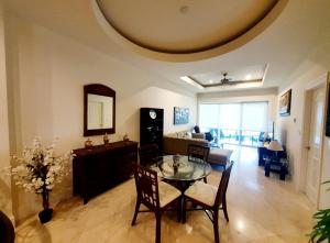 un soggiorno con tavolo, sedie e divano di Landmark by Villas Segovia a Cozumel