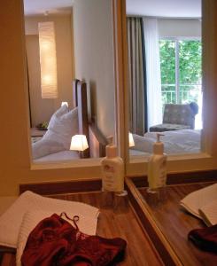 Habitación con espejo, cama y silla en Hotel am Schlosspark garni, en Husum