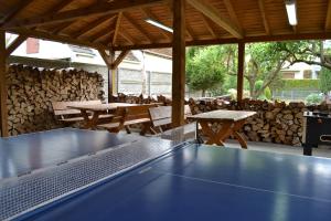 a ping pong table in a pavilion with tables and benches at Dom Gościnny Przystań in Międzywodzie