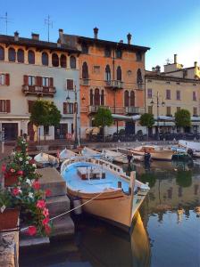 a group of boats docked in the water near buildings at Hotel Piroscafo in Desenzano del Garda
