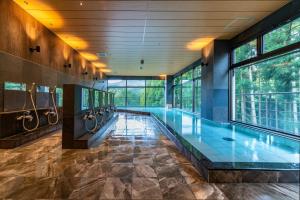 ein Hallenbad in einem Gebäude mit Fenstern in der Unterkunft Ryokan Nenrinbo in Kyoto