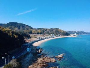 アパートメントホテル Mimoza في Sumoto: اطلالة على شاطئ به بيوت ومحيط