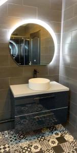 ein Bad mit einem Waschbecken und einem Spiegel in der Unterkunft chambre proche du circuit des 24h in Mulsanne