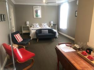 um quarto com uma cama, cadeiras e uma mesa em Athelstane House em Queenscliff