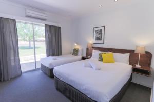 a hotel room with a large bed and a large window at Manjimup Kingsley Motel in Manjimup