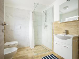 uma casa de banho com um chuveiro, um WC e um lavatório. em Affittacamere Ai Crocus em Cesclans