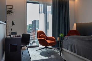 une chambre d'hôtel avec un lit, des chaises et une fenêtre dans l'établissement Thon Partner Hotel Norge, à Kristiansand